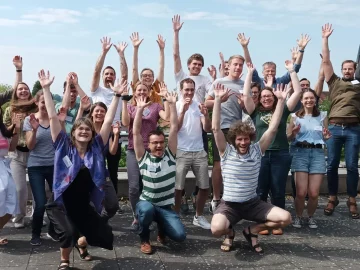 Gruppenbild auf einer Dachterasse von fröhlich in die Luft springenden Teilnehmenden des REGULUS-Workshops 